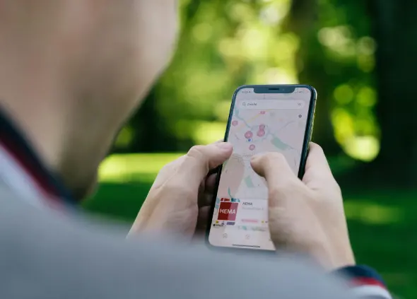 View over the shoulder of a man using his mobile phone - Touring with your mobile phone
