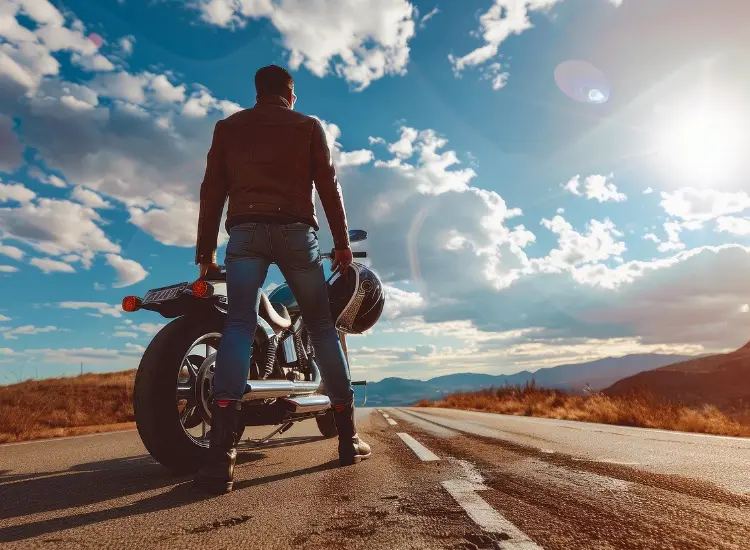 Man standing by his motorbike looking into the distance