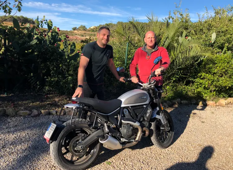 Mark and Toby stood by a motorbike in Spain